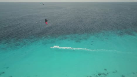 drone shot of a kitesurfer riding at high speed on a beautiful turquoise sea