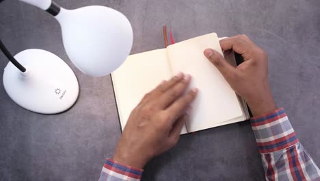 person studying with a notebook and lamp