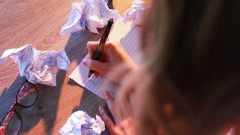 Woman-writing-and-crumpling-paper-on-her-desk-4k