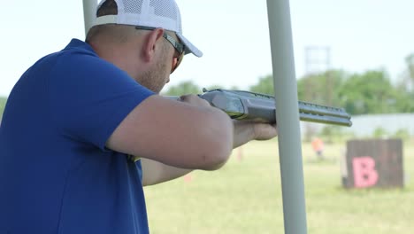 sportsman shoots from a double-barreled shotgun, a sports field for a shooting test is shooting at flying skeet