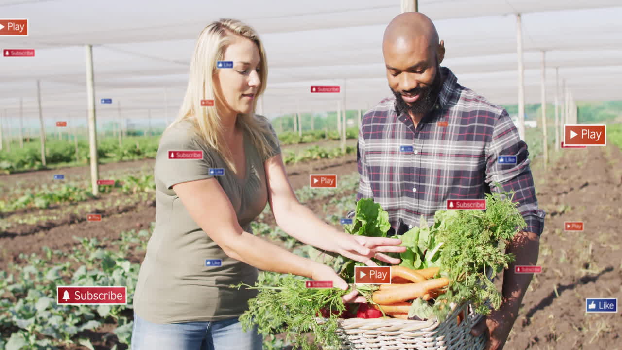 Two farmers holding basket in farm field, displaying floating subscribe, like and play icons