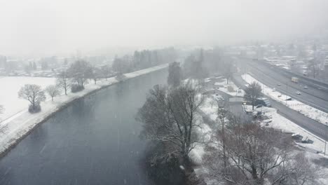 flying-over-a-river-next-to-the-highway-in-a-snow-blizzard