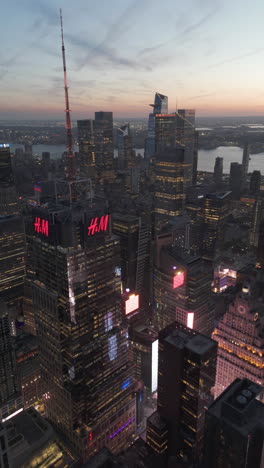 vertical drone shot of skyscrapers in times square and hudson yards, dusk in nyc