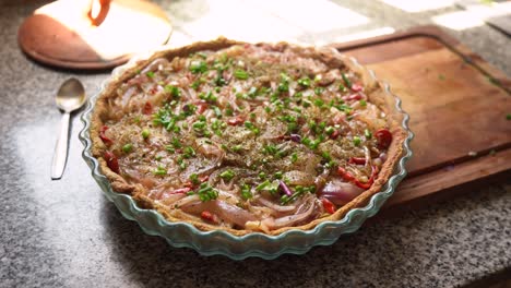 tarta de cebolla espolvoreada con cebollas verdes encima antes de hornear