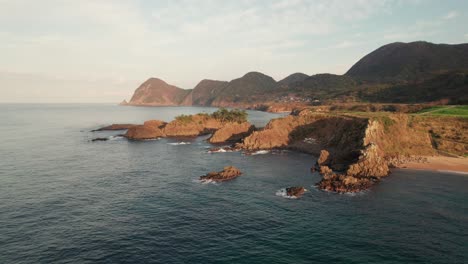 aerial drone fly above blue peninsula of kyotango kyoto japan travel landscape sea water floating slowly in panoramic clean environment, mountain range background