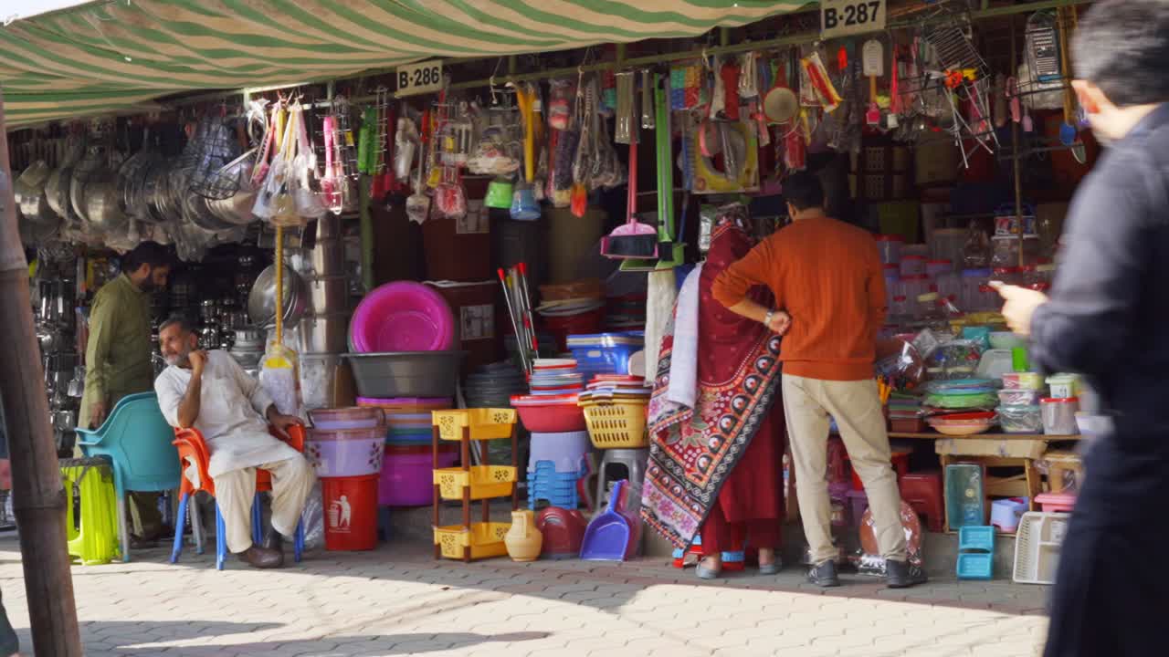 Busy Street Market in South Asia: People Shopping for Household Goods