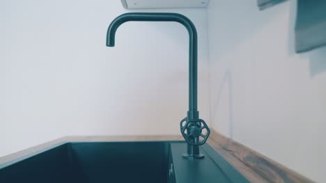 Vintage-Wasserhahn-über-Schwarzem-Waschbecken-Im-Modernen-Kücheninterieur
