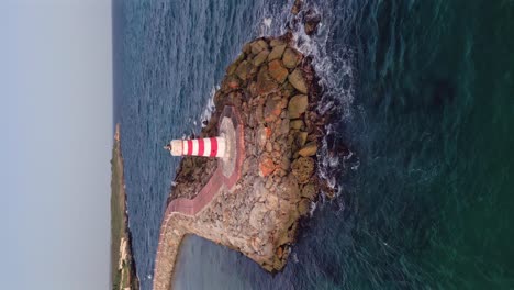 Vertical-view-Of-lighthouse-in-front-of-Marina-Hilton-Garden-Inn-hotel-on-the-Caribbean-sea-In-La-Romana,-Dominican-Republic