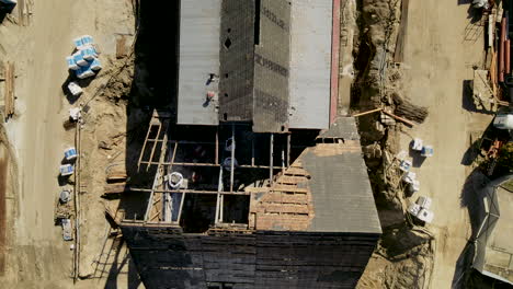 Broken-Roof-Of-Abandoned-House-Near-Construction-Site