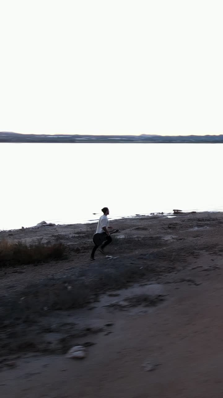 Person som går langs en fredelig innsjøbredd