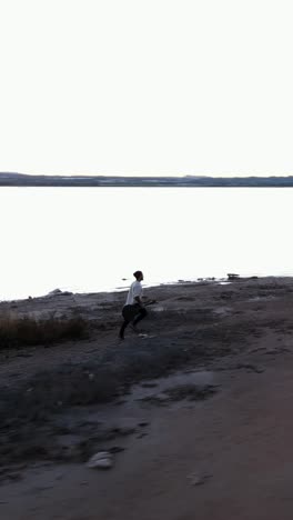 person walking along a serene lake shore