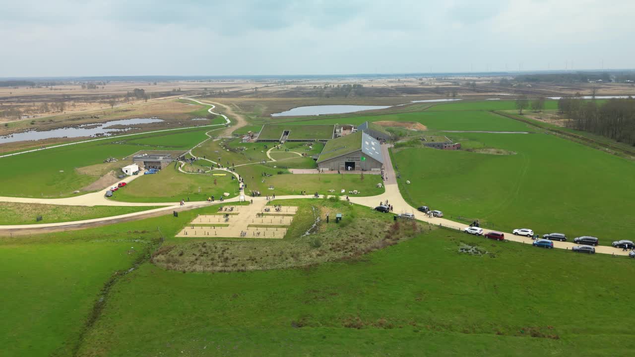 Aerial View Of People Walking To The Building With Grass Roof In Daytime