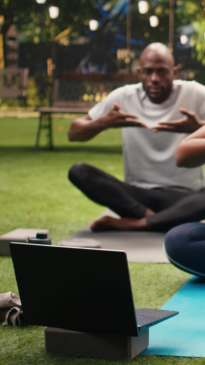 Vertical Video Young woman doing controlled breathing meditation in front of laptop