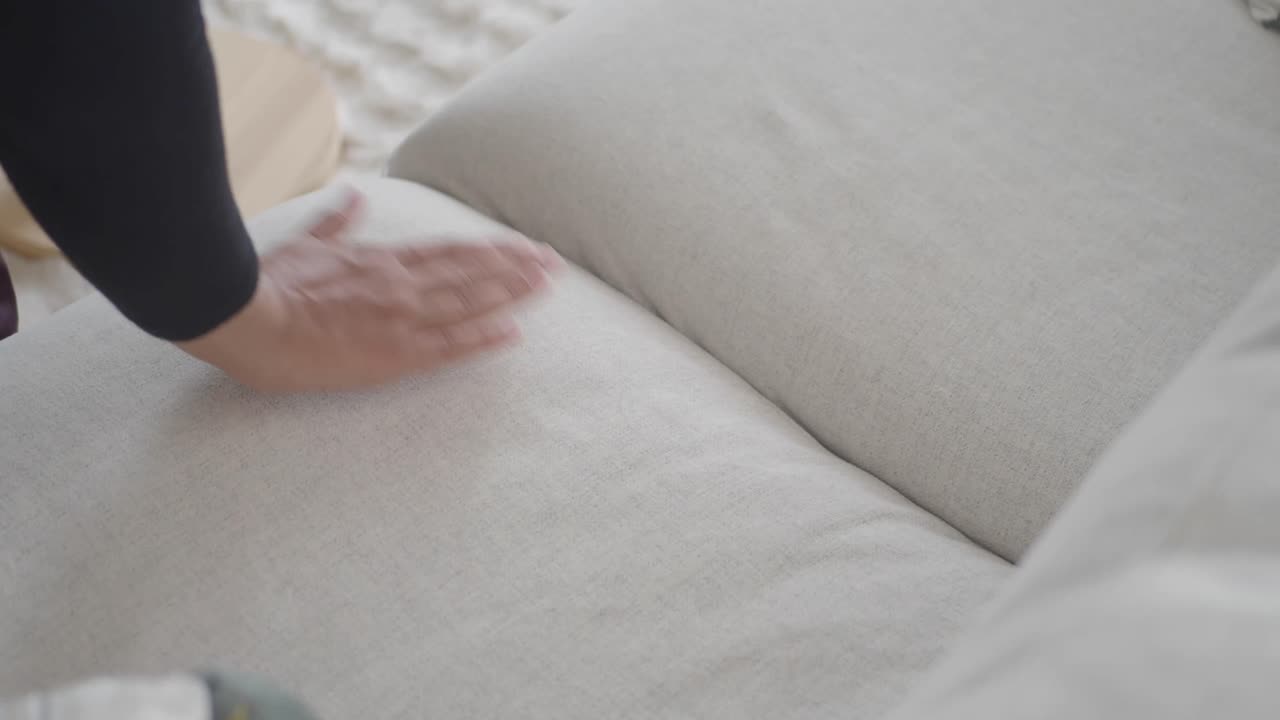 Close-up of a hand on a sofa cushion