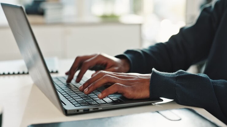 Person, die auf einem Laptop schreibt
