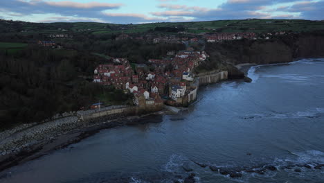 establishing drone shot towards robin hood's bay on cloudy morning uk