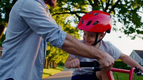 father teaching his son how to ride a bicycle