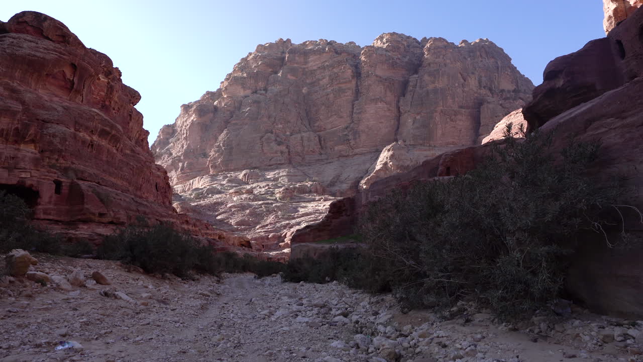caminando dentro del cañón en un camino rocoso a la ladera de la montaña en la antigua ciudad de petra
