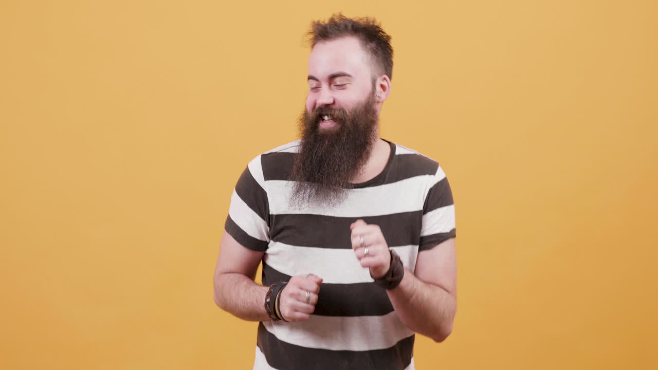 Man with beard posing in front of a yellow background