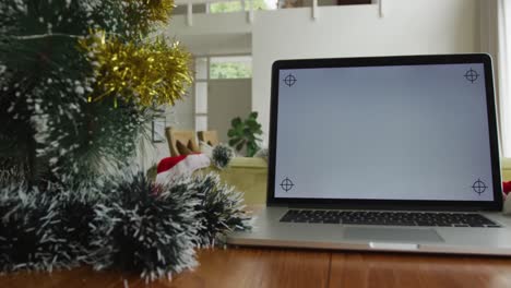 Nahaufnahme-Eines-Laptops-Mit-Kopierplatz-Auf-Dem-Bildschirm,-Der-Zu-Weihnachten-Auf-Dem-Tisch-Im-Wohnzimmer-Sitzt