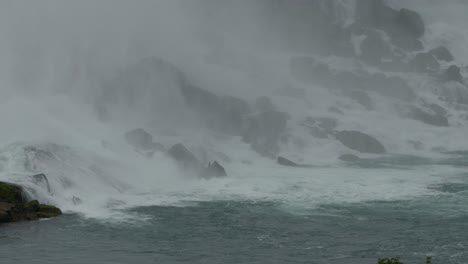 massive mist from huge and powerful waterfall on rocky coastline