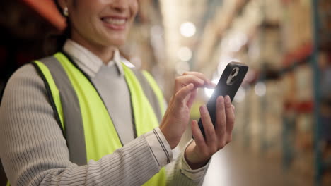 trabajador de almacén que utiliza un teléfono inteligente para la gestión del inventario