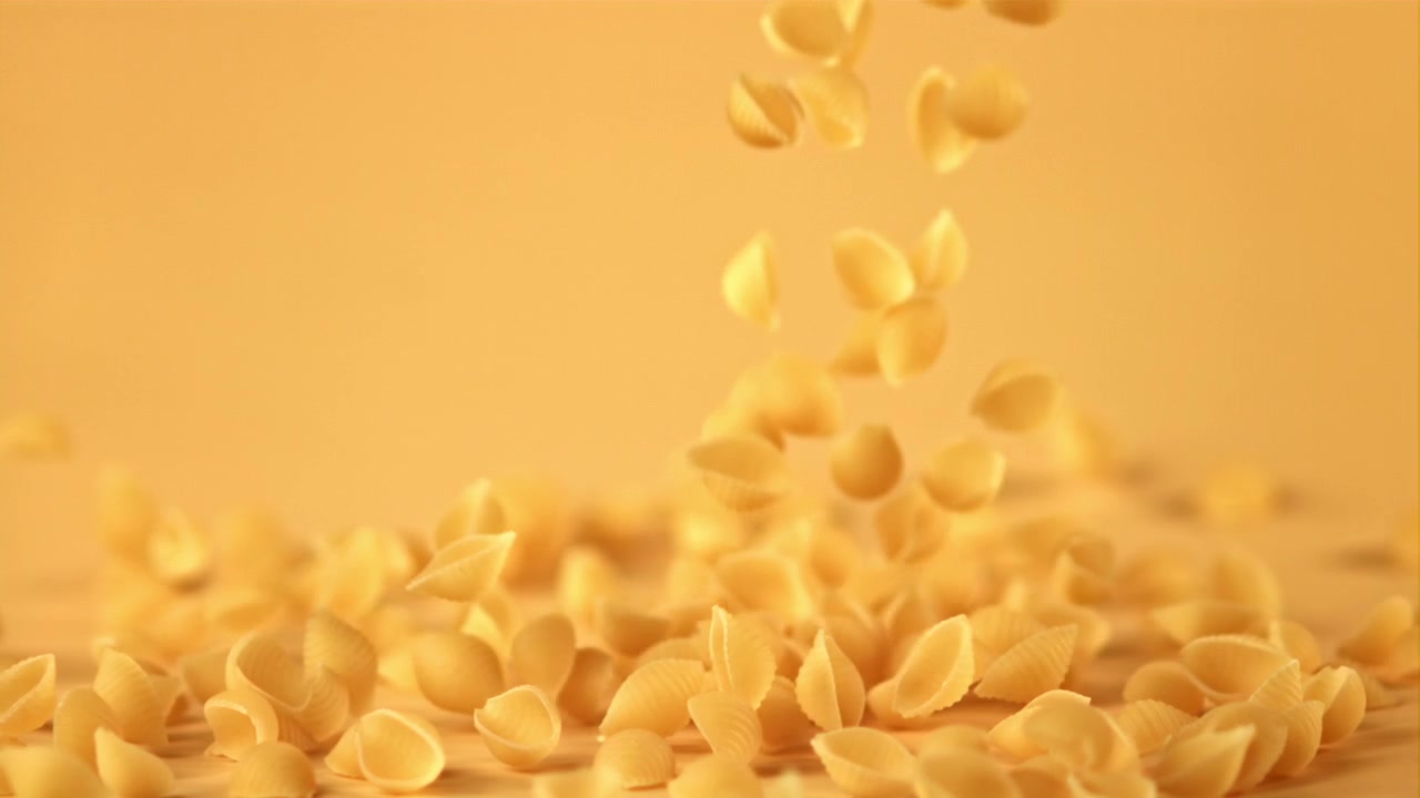 Conchiglie di pasta crude che cadono al rallentatore
