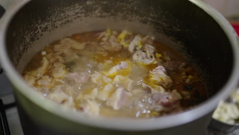 locro stew simmers in metal pot with visible corn and beans, traditional argentinian dish, closeup detail