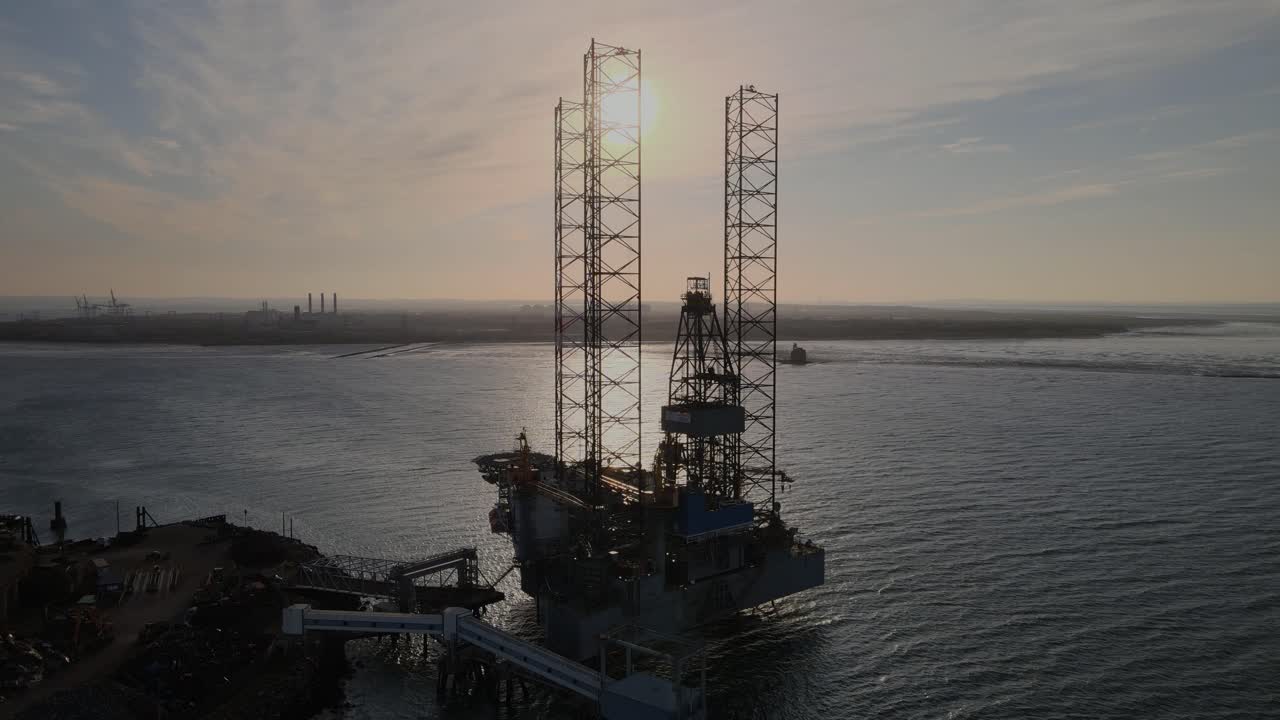 Tidlig morgensolopgang over Sheerness Kent og Isle of Sheppey med silhuetter af olieboreplatforme i vedligeholdelsesdokkene.