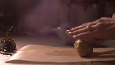 close up, woman's hands roll out raw dough with bare hands for baking. side view