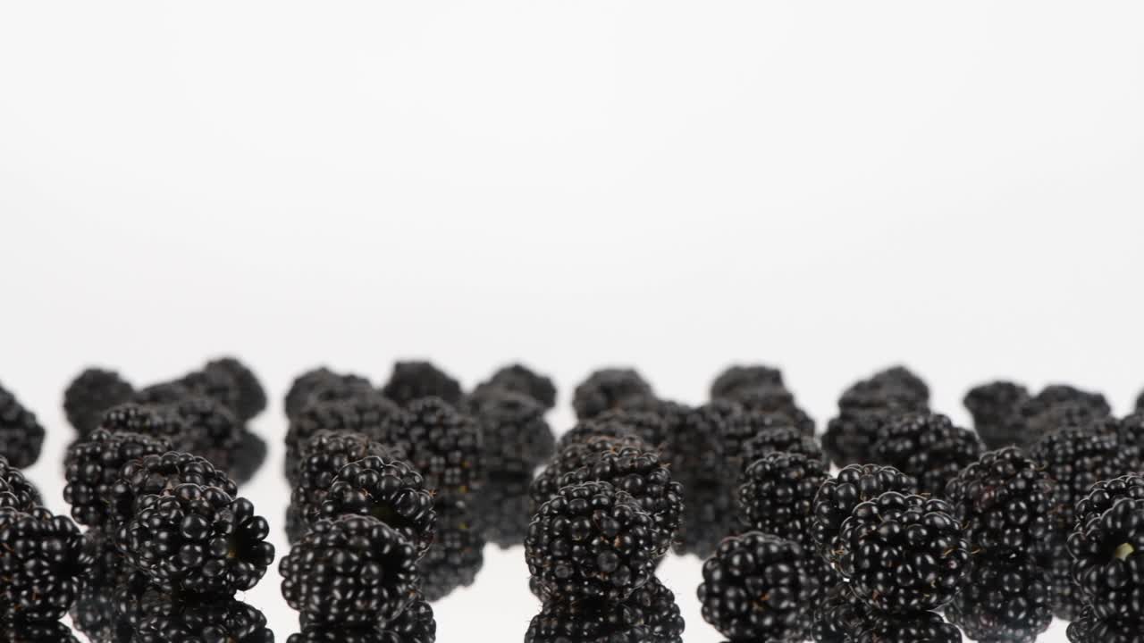 la fruta de la baya negra en el espejo plateado. espacio libre en la parte superior. vista lateral. movimiento en bucle. rotación 360.
