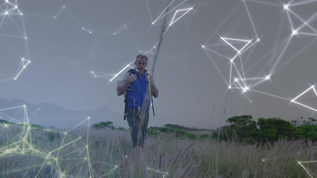 hombre caucásico de edad avanzada caminando por el campo, sobre una red móvil de conexiones