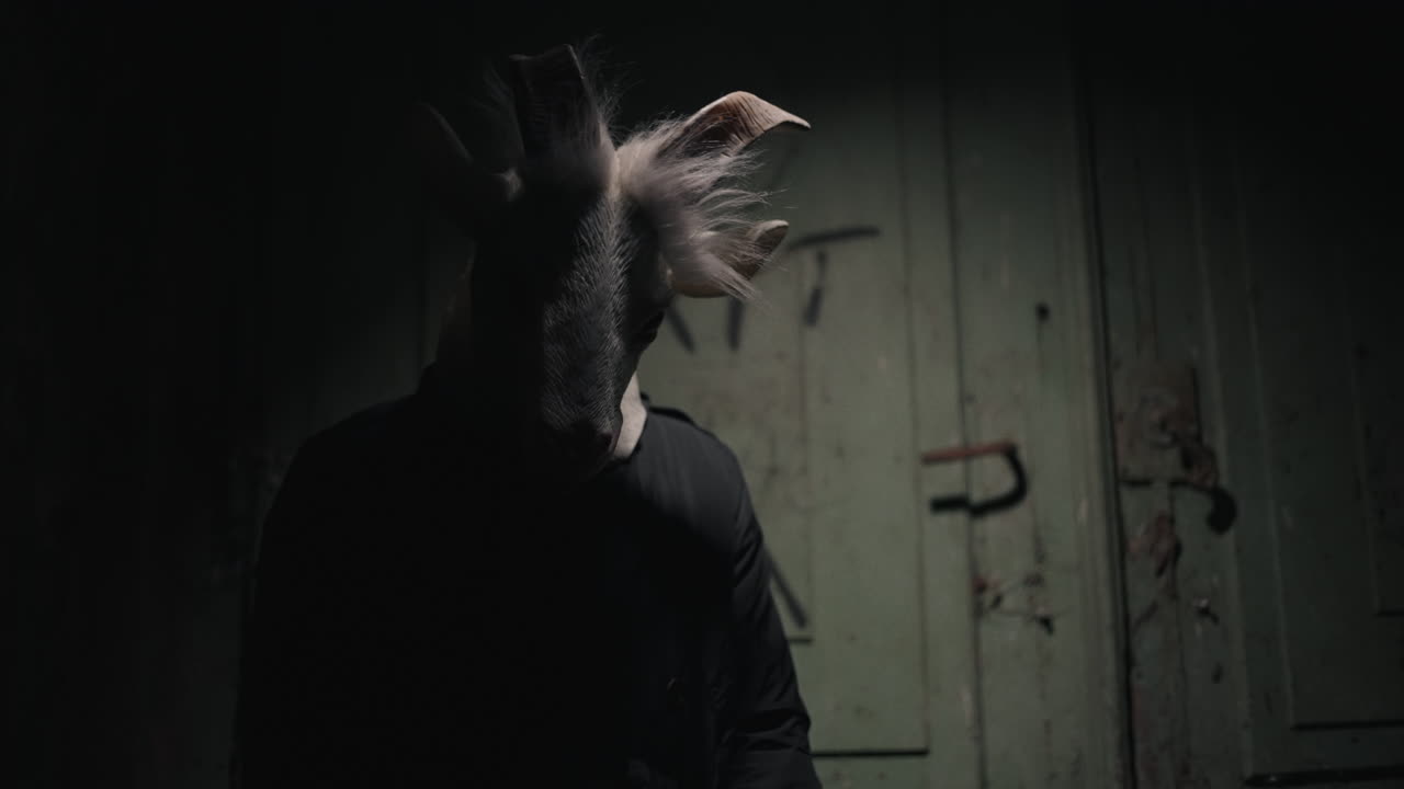 Person Wearing a Goat Mask in a Dark Room