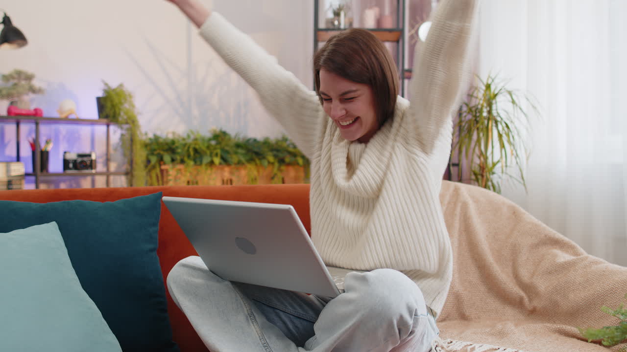 Amazed young woman use laptop computer receive good news message shocked by victory celebrate win