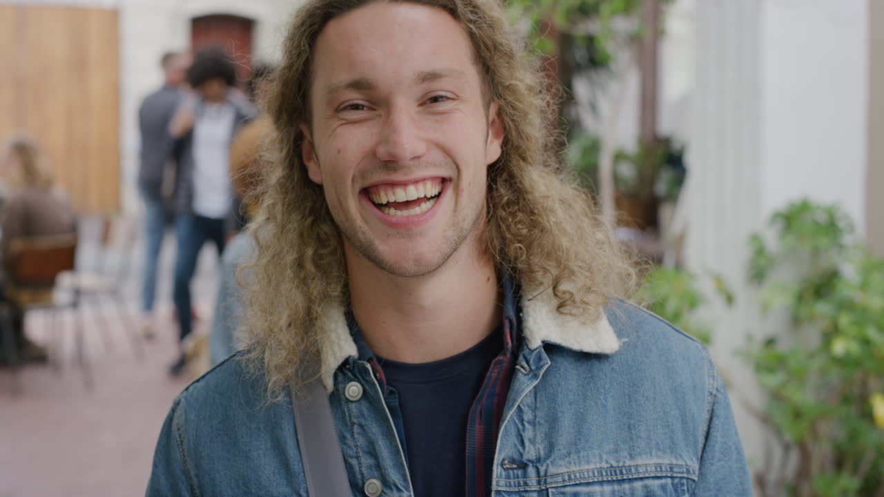 retrato de un joven atractivo riendo feliz mirando a la cámara disfrutando de un estilo de vida independiente en el aire libre urbano trasfondo del campus ocupado