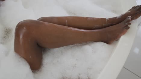 Piernas-De-Una-Mujer-Afroamericana-Atractiva-Relajándose-En-Un-Baño-De-Espuma-En-El-Baño