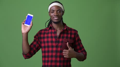 young handsome african man with dreadlocks against green background
