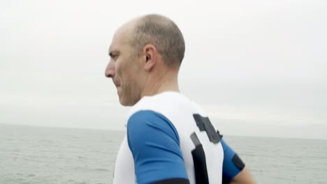 serious male athlete jogging along promenade