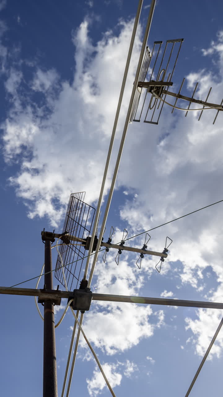 A timelapse of the sky and clouds with television aerials in the foreground