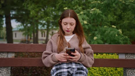 teenage girl using a smartphone in a park