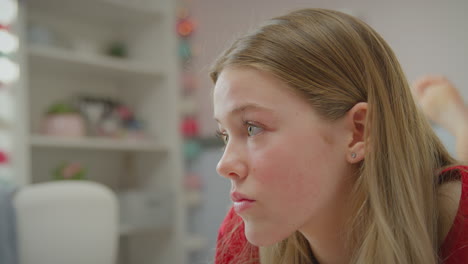 unhappy teenage girl wearing orthodontic braces lying on bed at home turns to face camera and smiles - shot in slow motion