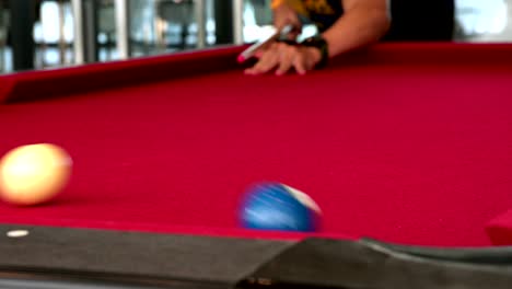 jugando al billar en la mesa roja. esto es deporte.