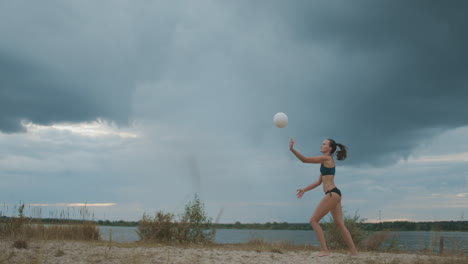 Schlanke-Junge-Frau-Springt-Und-Schlägt-über-Den-Ball-Bei-Einem-Beachvolleyball-Zeitlupenspiel