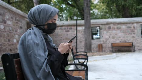 Maskiertes-Hijab-Junges-Mädchen,-Das-Das-Telefon-Bedient