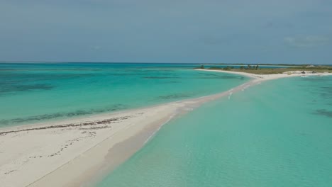 tomada lenta del avión no tripulado de la barra de arena entre dos islas tropicales cayo agua en los rocas, venezuela