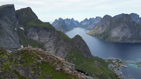 reinebringen hike in lofoten islands, norway - aerial view of people enjoy view on top of the mountain