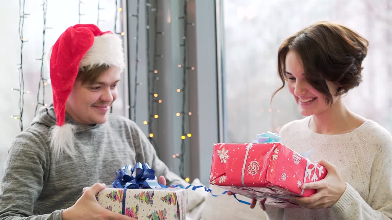 창문 에서 크리스마스 선물을 주고받는 부부