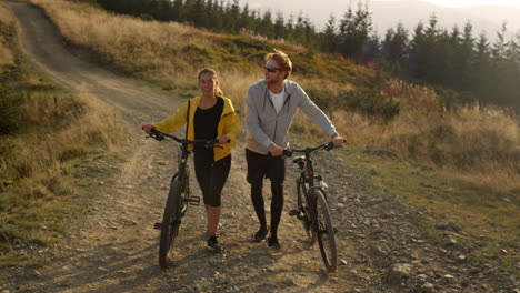 cyclists with bicycles walking on road