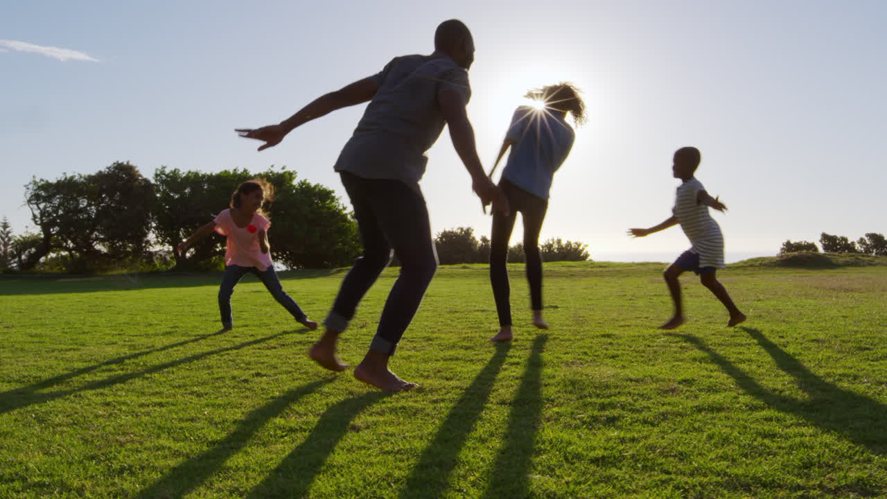 joven familia negra jugando en un campo en verano