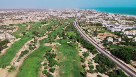 una vista aérea de un campo de golf al lado de una playa con muchos árboles y hierba verde desde arriba en túnez djerba